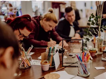 Stifte und Papier, Menschen schreiben in einem kreativen Raum.