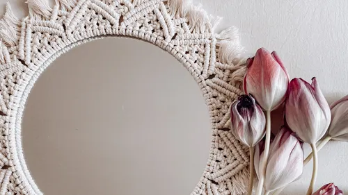 Round mirror with macrame frame and tulips.