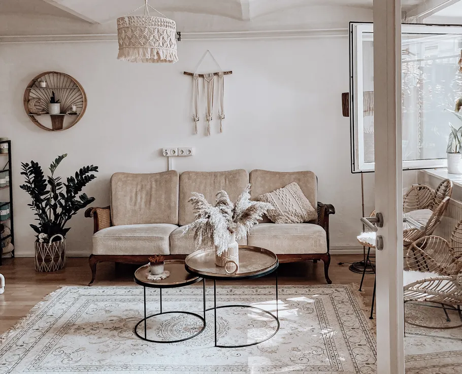 Gemütliches Wohnzimmer mit beigen Möbeln und Pflanzen.