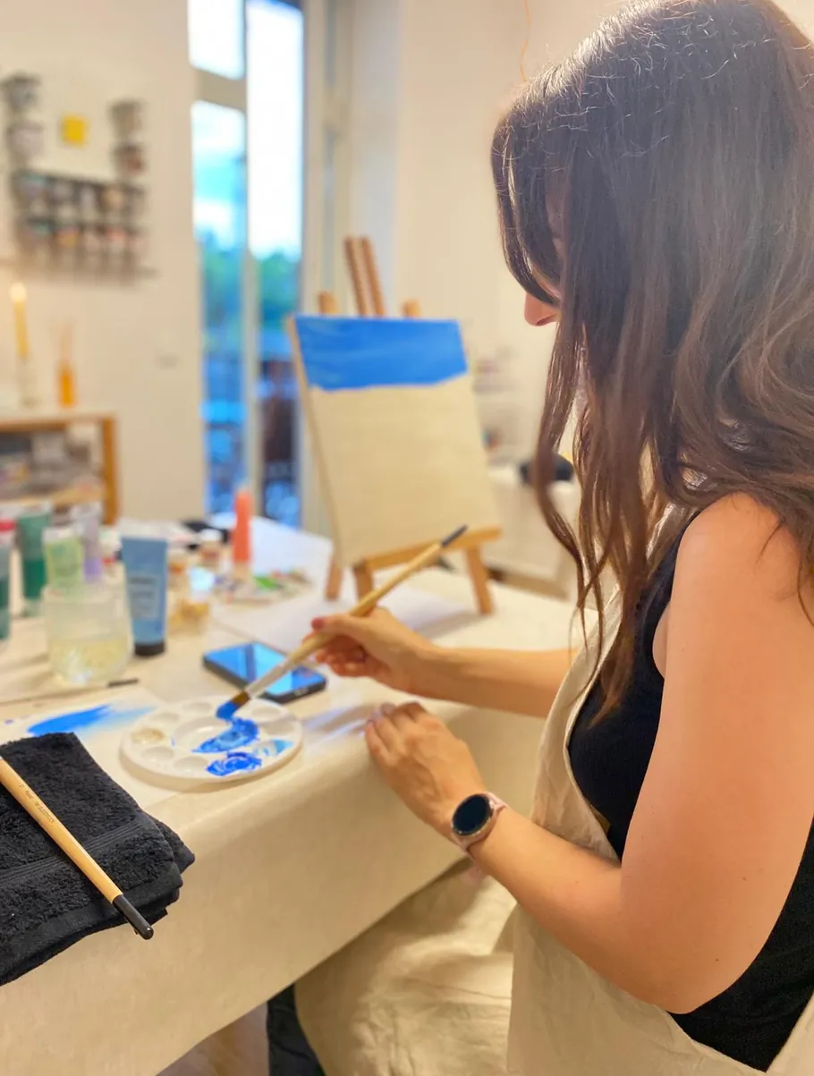 Frau malt auf Leinwand im Kunststudio.