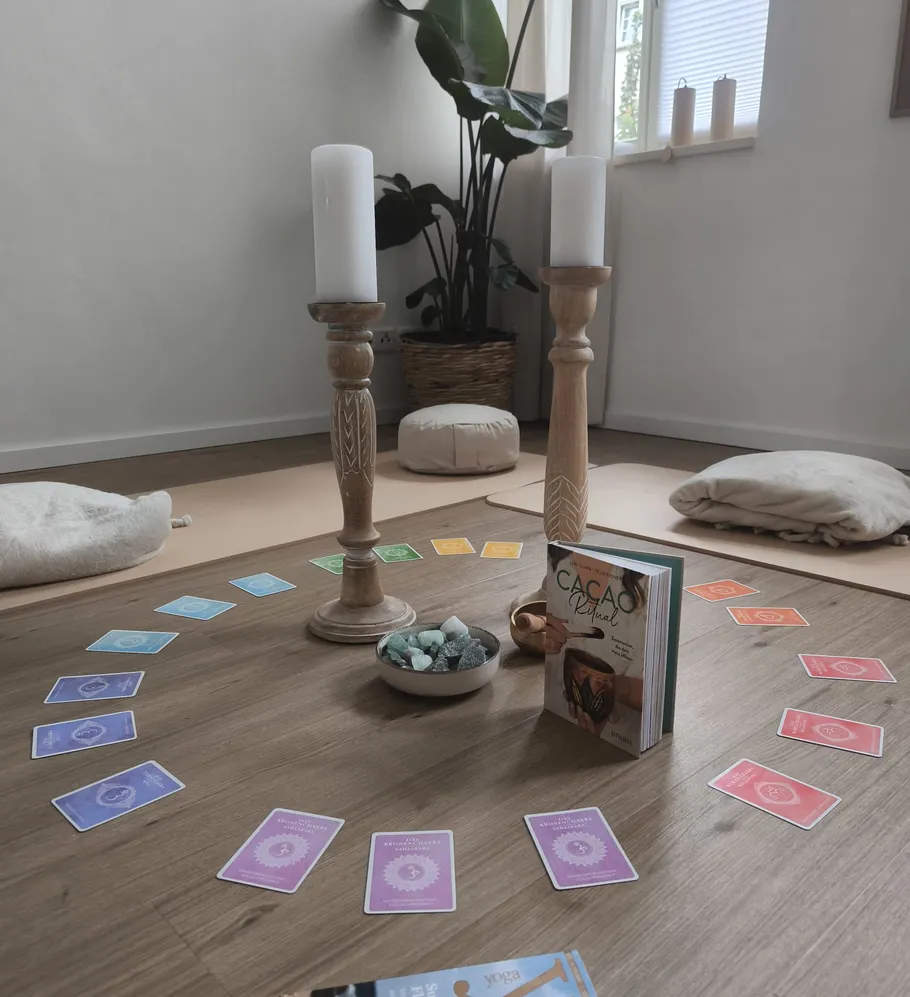 Candles, cards, book on floor in circle.