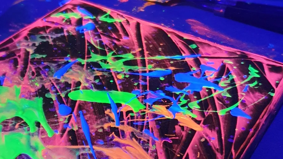 Neon paint splatters under blacklight.