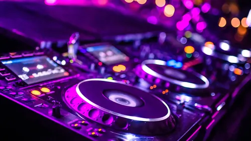 DJ equipment with colorful lighting in club.