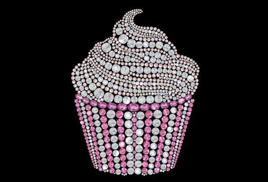 Cupcake-Design aus rosa Edelsteinen, schwarzer Hintergrund.