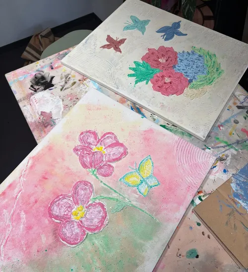 Colorful flower paintings on a table surface.