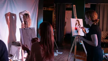 Artists sketching a model in an art studio.