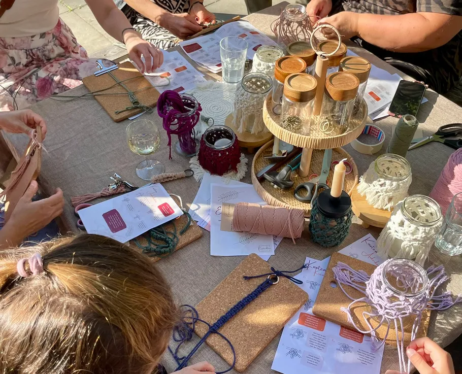 People doing macramé crafting at a table.