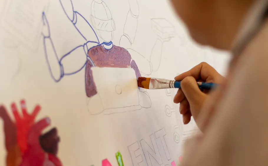 Person painting illustration on white canvas.