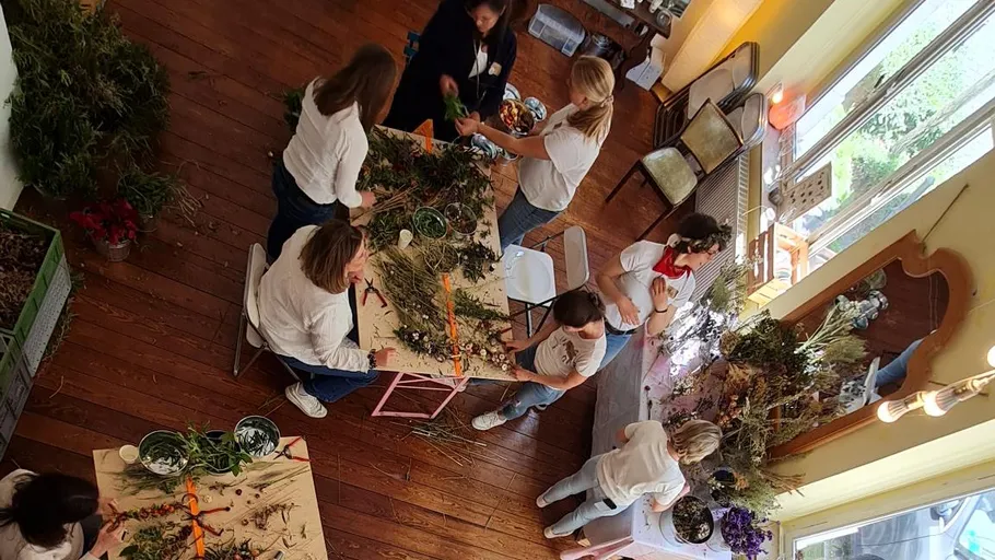 People arranging flowers on tables indoors.