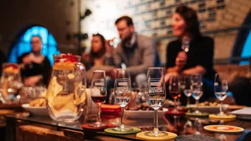 Glasses on table with people in background.