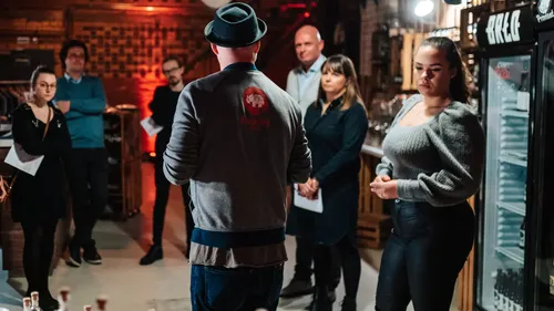 Person spricht zu aufmerksamer Gruppe in Bar.