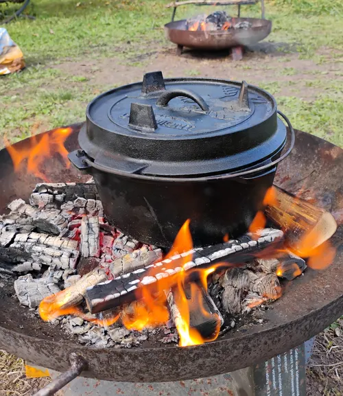 Gusseisentopf auf offenem Feuer im Freien erhitzt.