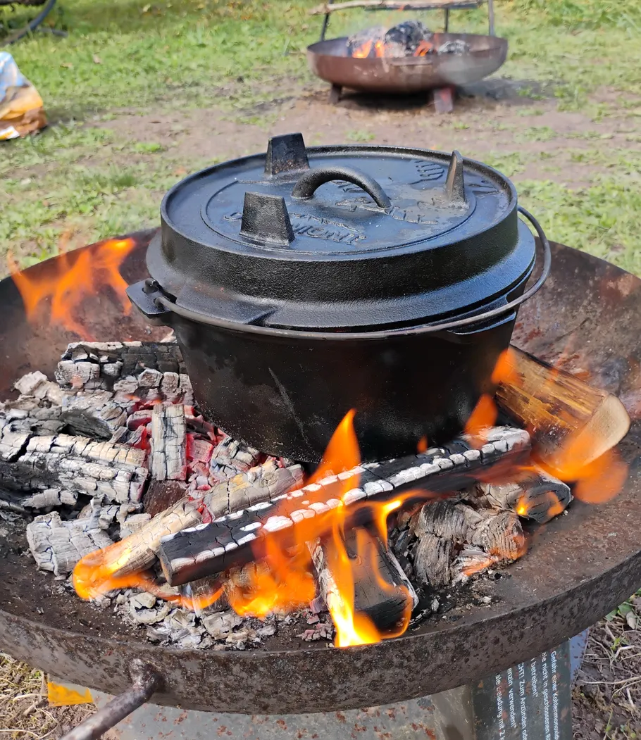 Gusseisentopf auf offenem Feuer im Freien erhitzt.