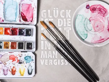 Watercolors and brushes on a light background. Text: `HAPPINESS IS THE TIME WHEN YOU FORGET. `