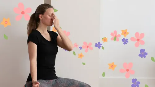 Woman practicing yoga breathing with floral background.