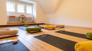 Yoga mats and bolsters in a calm studio.