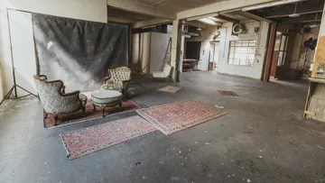 Leeres Studio mit Vintage-Stühlen und Teppichen.