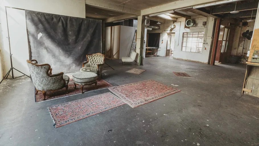 Leeres Studio mit Vintage-Stühlen und Teppichen.