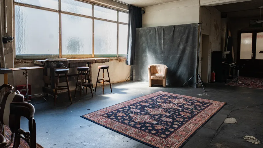 Leeres Studio mit Stuhl und Teppich.