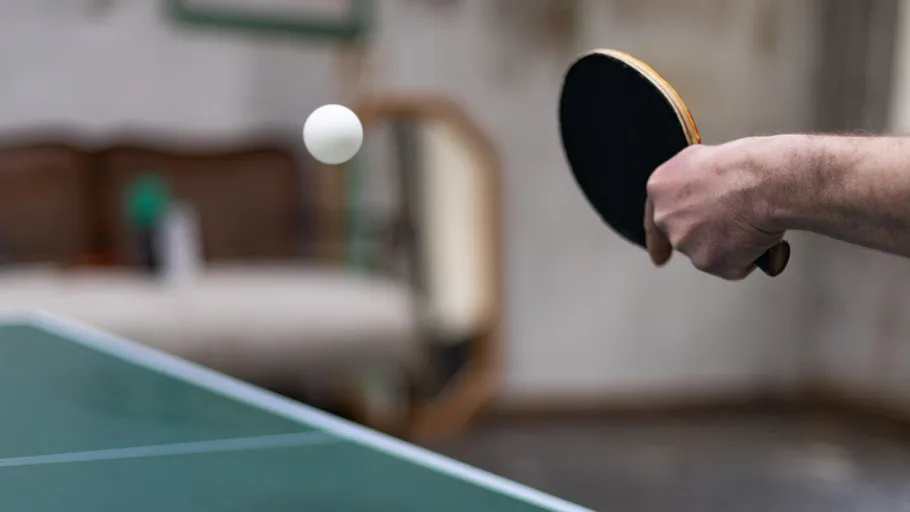 Person playing ping pong indoors.