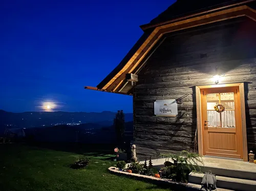 House lit at night with moon view.