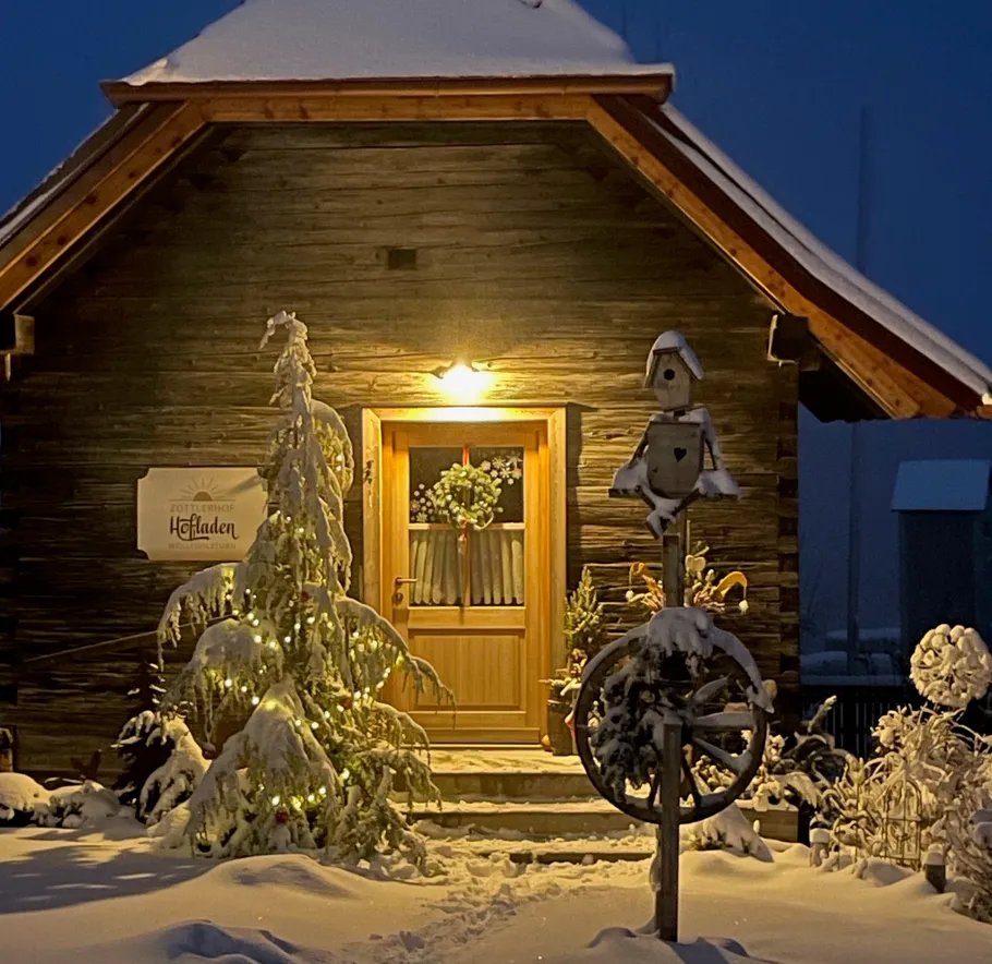 Snow-covered wooden cabin with warm lights.