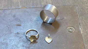 Ringe und Anhänger auf einem Werktisch.