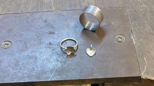 Ringe und Anhänger auf einem Werktisch.