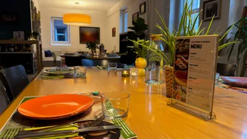 Restauranttisch mit Menü und Dekoration gedeckt.