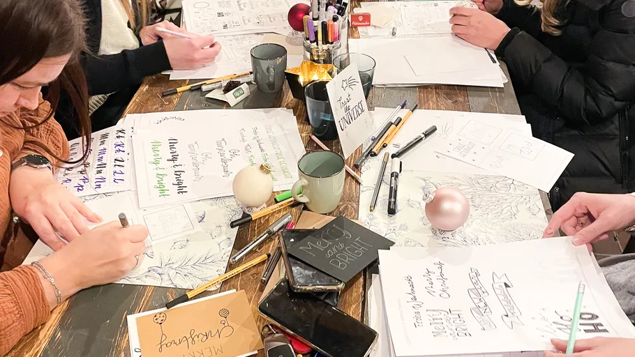 People crafting at a table with papers.