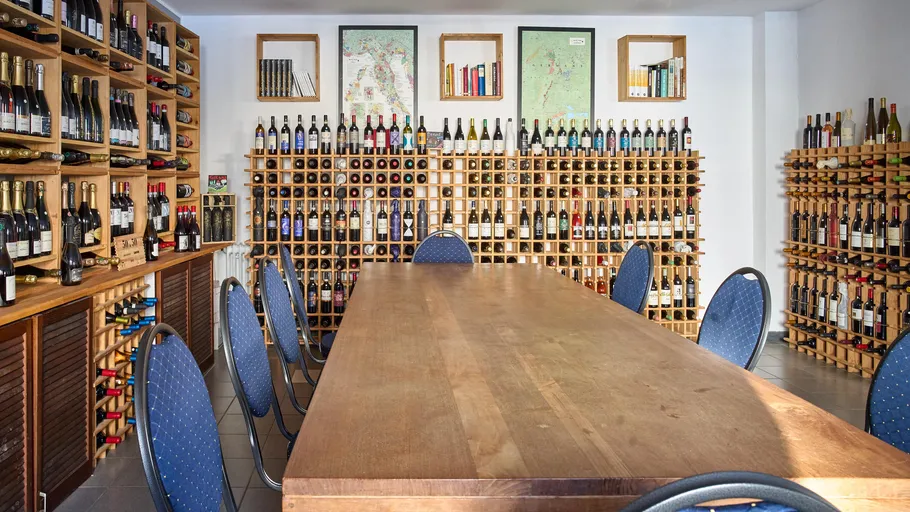 Room with wine bottles and wooden table.