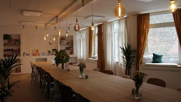 Langer Tisch mit Pflanzen in gemütlichem Raum.