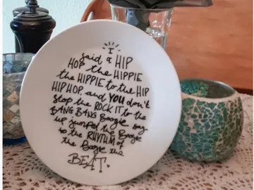 White plate with handwritten text, decorative table setting.