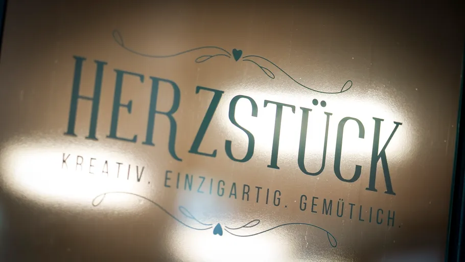 Sign with decorative text on a shiny surface.