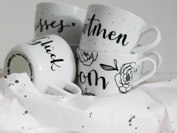 Coffee mugs lie chaotically on crumpled paper.
