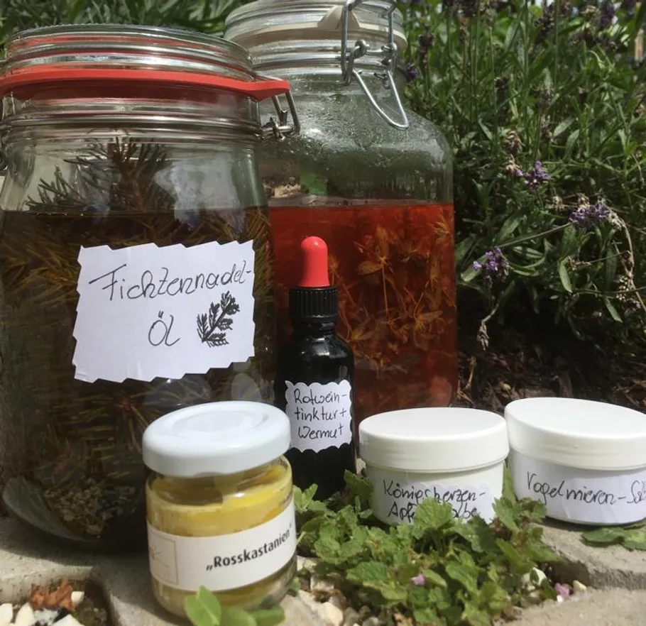 Jars of homemade herbal remedies outdoors.