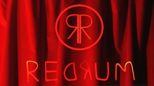 Red lettering on red curtain background.