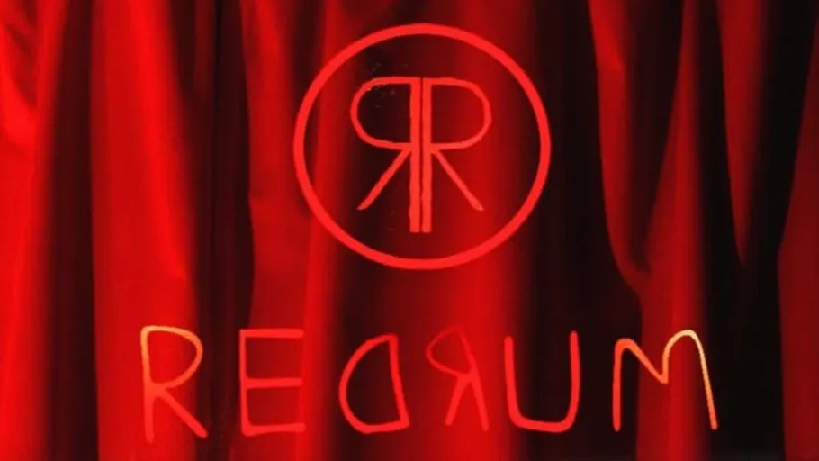 Red lettering on red curtain background.