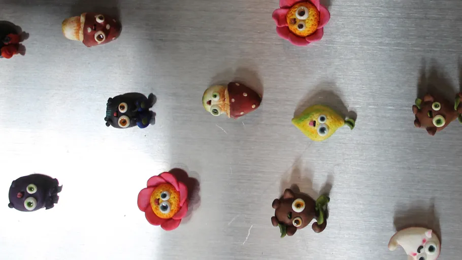 Bunte Tonfiguren auf Metallfläche präsentiert.