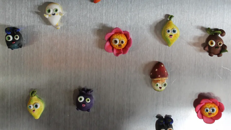 Colorful clay figures displayed on a metal surface.