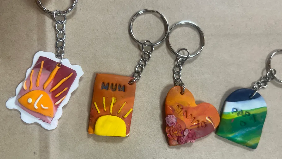 Colorful handmade keychains on a wooden surface.