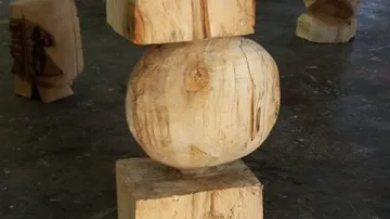 Holzskulptur mit geometrischen Formen auf Boden.