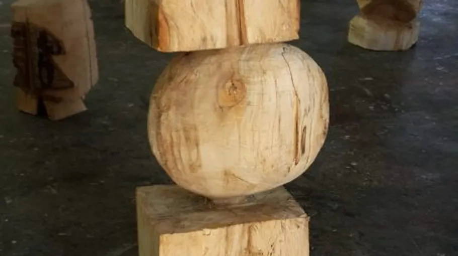 Holzskulptur mit geometrischen Formen auf Boden.