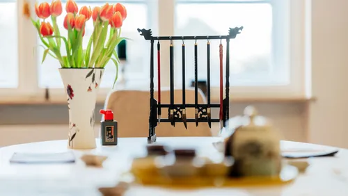 Vase mit Tulpen auf Tisch am Fenster.