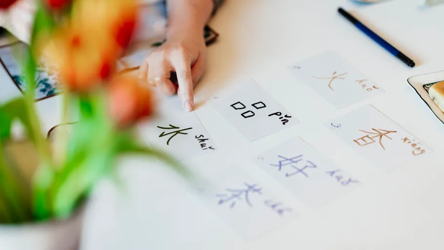 Hand pointing at flashcards on table.