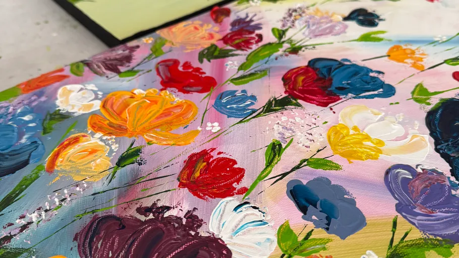 Colorful painted flowers on canvas, vibrant background.