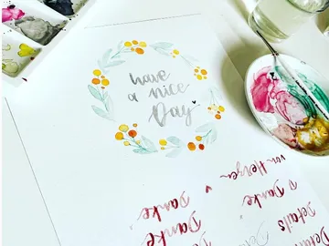 Wasserfarben zeichnen Schriftzug „have a nice day“ auf Papier.
