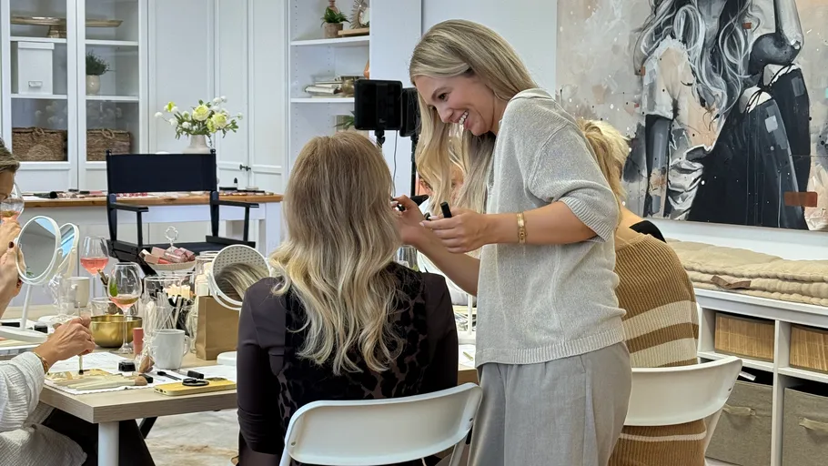 Woman styling another woman's hair in a studio.