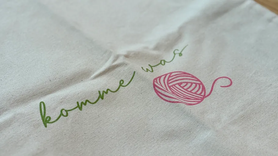 Text and yarn ball printed on fabric.