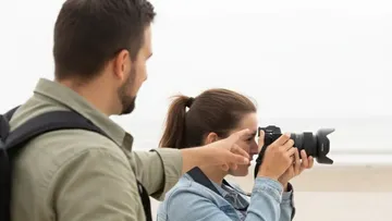 Zwei Personen besprechen Fotografie am Strand.